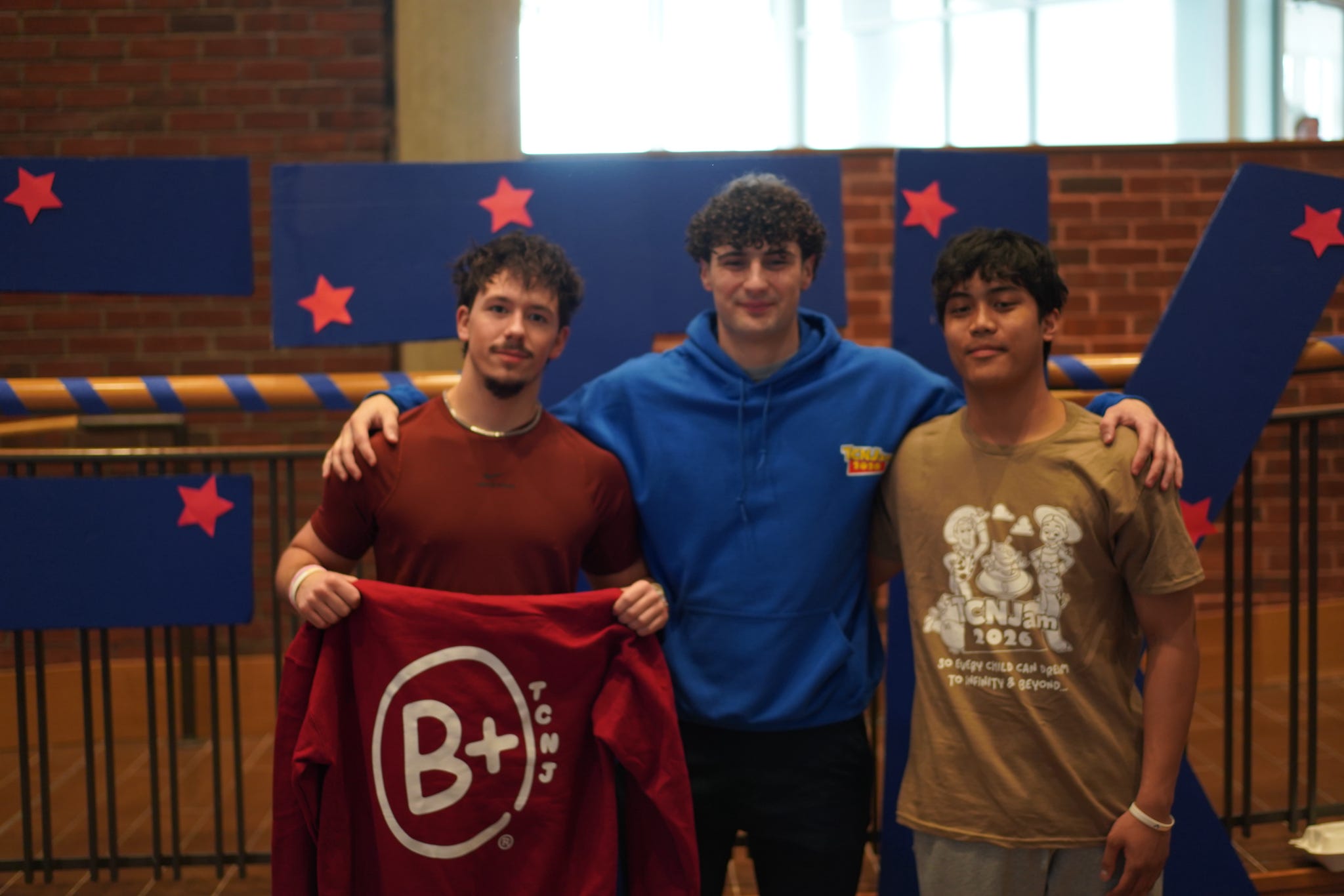 SAE members together at TCNJam holding a B+ shirt